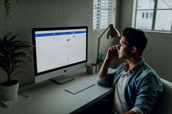 Un homme regarde son écran d'ordinateur en étant pensif