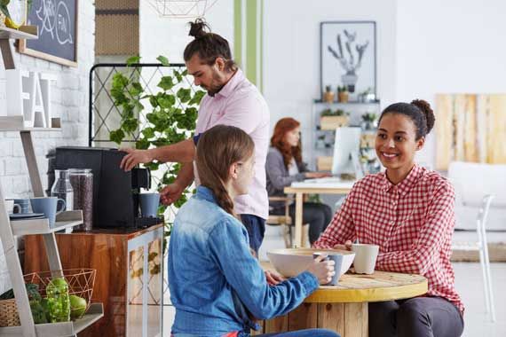 Des employés près d'une machine à café.